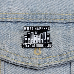 Gros plan d'un badge émaillé club de lecture avec lettrage blanc sur veste en jean