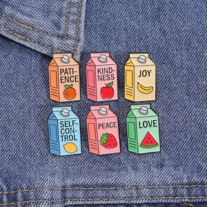 Close-up of six colorful milk carton enamel pins pinned onto a blue denim fabric jacket