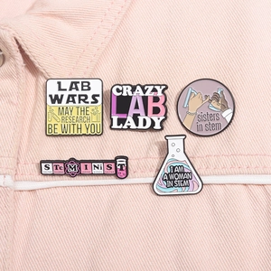 Set of STEM themed enamel pins with science quotes on pink denim jacket pocket detail