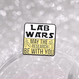 Lab Wars enamel pin with science lab beaker icons and May the Research Be With You quote