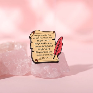 Broche en émail en forme de parchemin et plume posée sur du quartz rose naturel