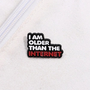 Macro shot of 'I AM OLDER THAN THE INTERNET' enamel pin pinned on white canvas texture