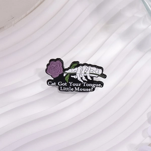 Gothic skeleton hand holding a purple rose enamel pin with artistic quote text