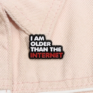 Macro shot of I AM OLDER THAN THE INTERNET enamel pin on a pink denim collar lapel