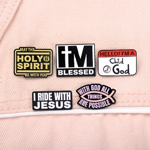 Detail of religious enamel pins with Holy Spirit and Blessed text on pink denim