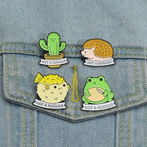 Detailed view of four cartoon animal pins with NOT A HUGGER banners on denim jacket