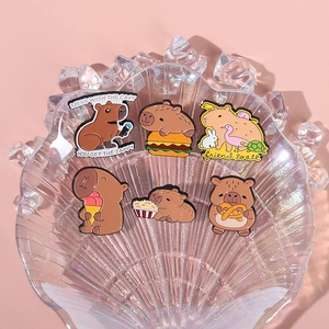 Set of six cute capybara enamel pins with food and animal themes on shell tray