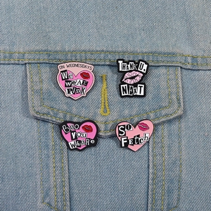 Détail de pins émaillés cœur et lèvres sur veste en jean avec citations de films