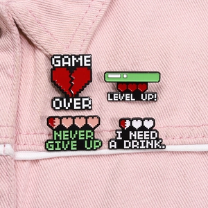 Set of 4 pixel art enamel pins with retro gaming text on pink denim jacket fabric