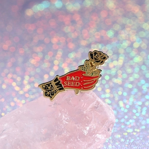 Enamel black rose hand badge featuring BAD SEED text and galaxy sleeve on pink quartz