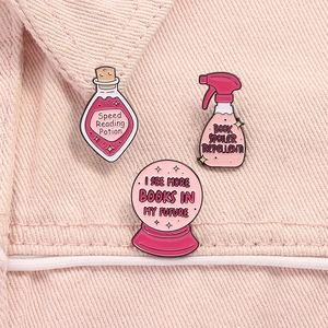 Detailed view of pink enamel pins featuring book lover motifs and crystal ball design