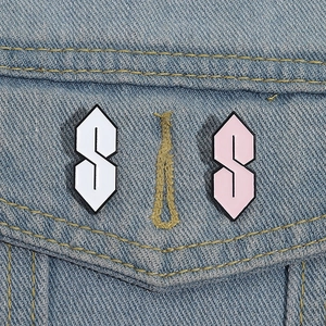 Detail of two Cool S enamel pins in white and pink on light blue denim fabric pocket