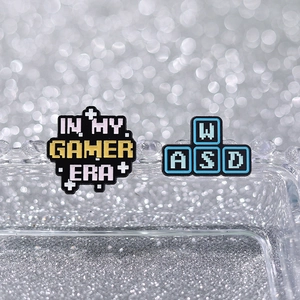 Two-piece set of enamel pixel gaming pins featuring Gamer Era text and WASD keys