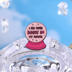 Pink potion bottle enamel pin featuring 'I SEE MORE BOOKS IN MY FUTURE' text on blue background