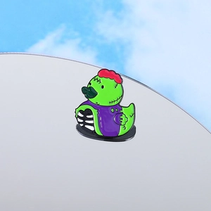 Broche émaillée de canard zombie vert vif avec des détails décalés en violet et rouge