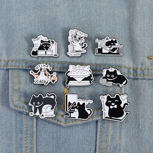 Set of 9 black and white cat enamel pins with humorous phrases on denim jacket