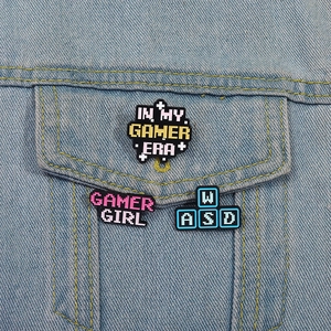 Close-up of pixel style Gamer Girl enamel pins on a blue denim jacket pocket