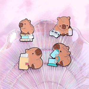 Detail of four Capybara enamel pins showing cute study and office scenes on a shell tray