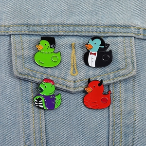 Set of four Halloween themed enamel pins with duck designs on a denim jacket pocket