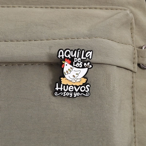 Funny black enamel chicken brooch with quote pinned on green canvas bag