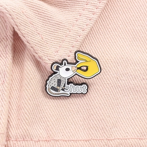 Detailed view of creative possum metal badge pinned on pink denim jacket with shut sign