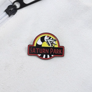 Cartoon enamel pin featuring a black and white snake design with Saturn Park text badge