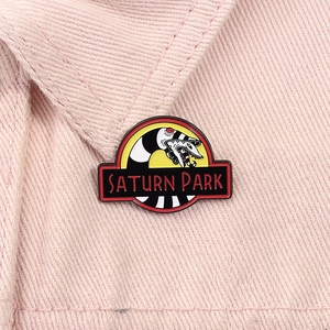 Macro detail of Beetlejuice sandworm enamel pin with Saturn Park text on pink denim