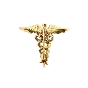 Golden Caduceus brooch with wings and double snake staff design on white background