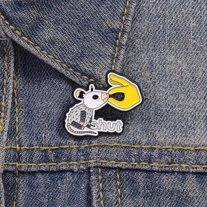Funny white possum enamel pin with shut text on blue denim jacket pocket