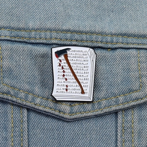 Détail de pin's en émail avec design hache et machine à écrire Shining sur veste en jean