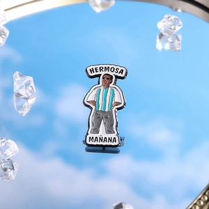 Badge en émail personnage de mème avec texte Hermosa Mañana sur fond de ciel réfléchi