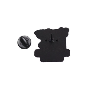 Macro view of matte black enamel pin back with secure rubber clutch and textured metal base
