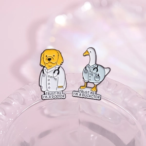 Enamel pins featuring a golden retriever dogtor and duckctor on textured glass edge