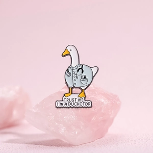 Cartoon doctor duck enamel pin with 'Trust Me I'm a Duckctor' pun on pink stone