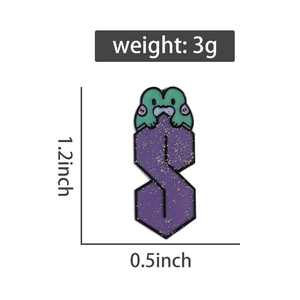 Detailed macro view showing the fine purple glitter and green enamel on the metal brooch