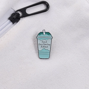 Detail of Baja Blast drink enamel pin with slogan on white canvas bag with zipper