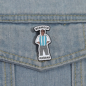 Détail d'une broche en émail avec texte Hermosa Mañana sur une poche en jean