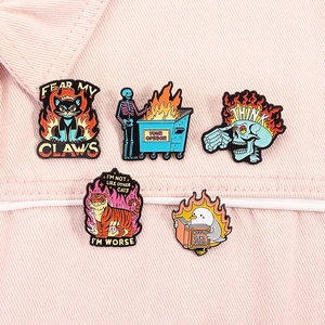 Detail of five punk style enamel pins with slogans on pink denim fabric material