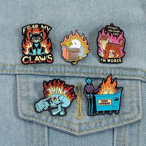 Detail of colorful enamel metal pins with goth animal motifs on blue denim jacket