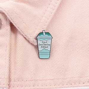 Detail of Baja Blast drink enamel pin with motivational text on pink denim jacket