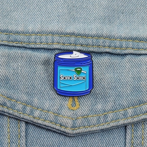 Detail of blue Sana Sana enamel pin styled on light blue denim jacket pocket