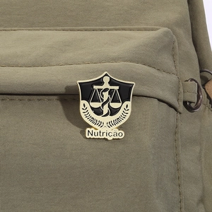 Detail of a vintage gold medical shield badge featuring Nutrition text on a green backpack
