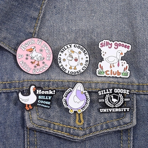 Détail de six pin's créatifs Silly Goose en émail sur une poche de veste en jean