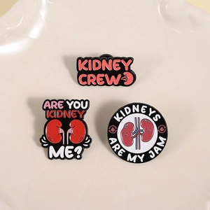 Three-piece red kidney enamel brooch set with humorous medical puns on a ceramic plate