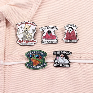 Detail view of 5 enamel pins with Even Baddies Get Saddies text on pink denim fabric