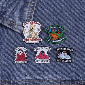 Five assorted punk enamel skull and frog pins with Even Baddies Get Saddies slogan