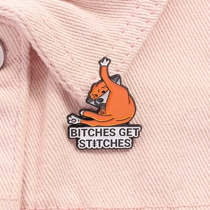 Macro detail of enamel dog pin with slogan on pink denim fabric material