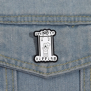 Dettaglio della spilla in smalto creativa con scritta 'say NO to kipping' su denim