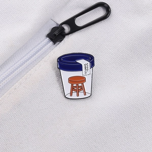 Creative stool sample enamel pin accessory attached to a white canvas backpack strap
