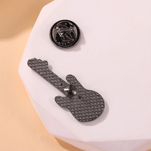 Back view of a white guitar metal brooch with silver textured finish and butterfly clutch